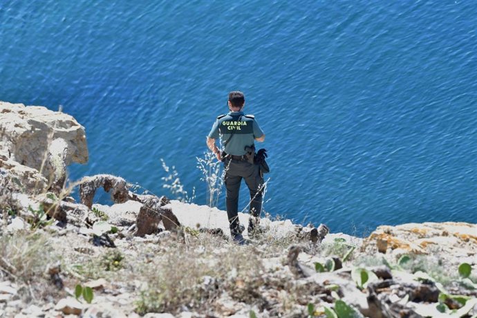 Archivo - Un agente de la Guardia Civil observa la costa.