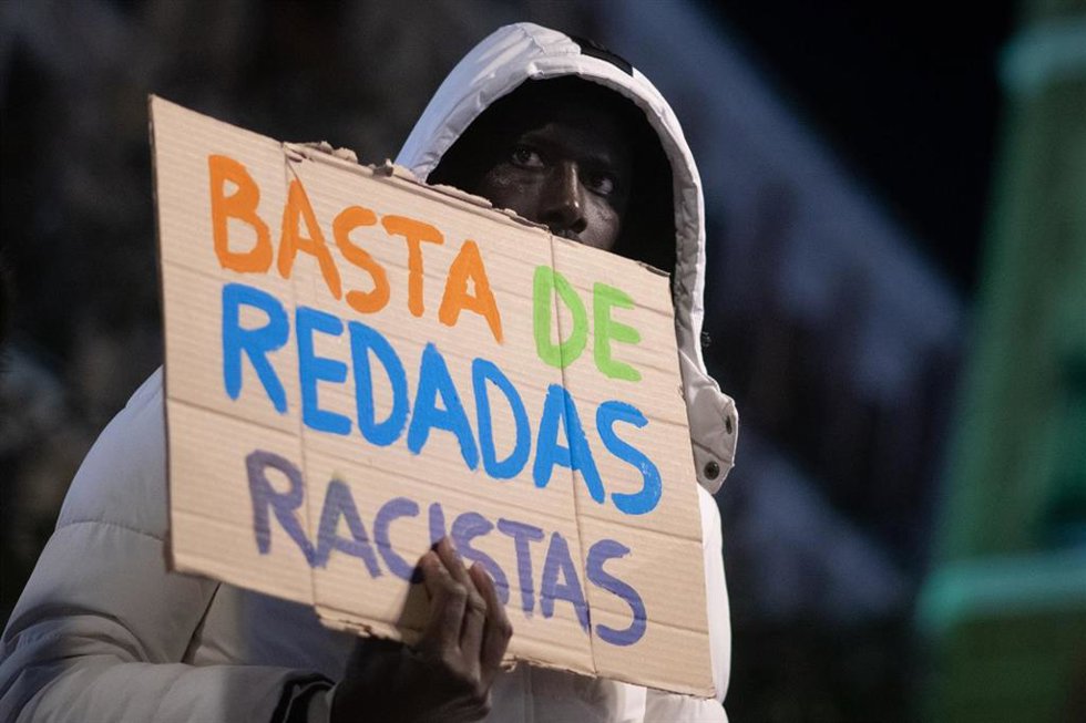 Archivo - Una persona sujeta un cartel durante la XIII Marcha por la Dignidad, en Lavapiés, a 6 de febrero de 2026, en Madrid (España). La marcha se celebra bajo el lema ‘Tarajal nunca más. El racismo mata. La memoria resiste’.