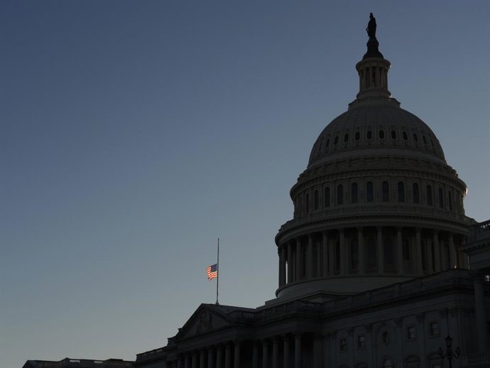 Archivo - 09 January 2021, US, Washington: A US flag flies at half-mast at the US Capitol in memory of police officer Brian Sicknick. Sidnick died as a result of injuries sustained during a riot by pro-Trump supporters who stormed and vandalized the Capit