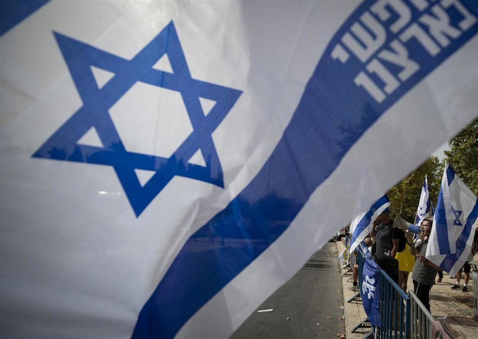 Archivo - Un manifestante ondea la bandera de Israel