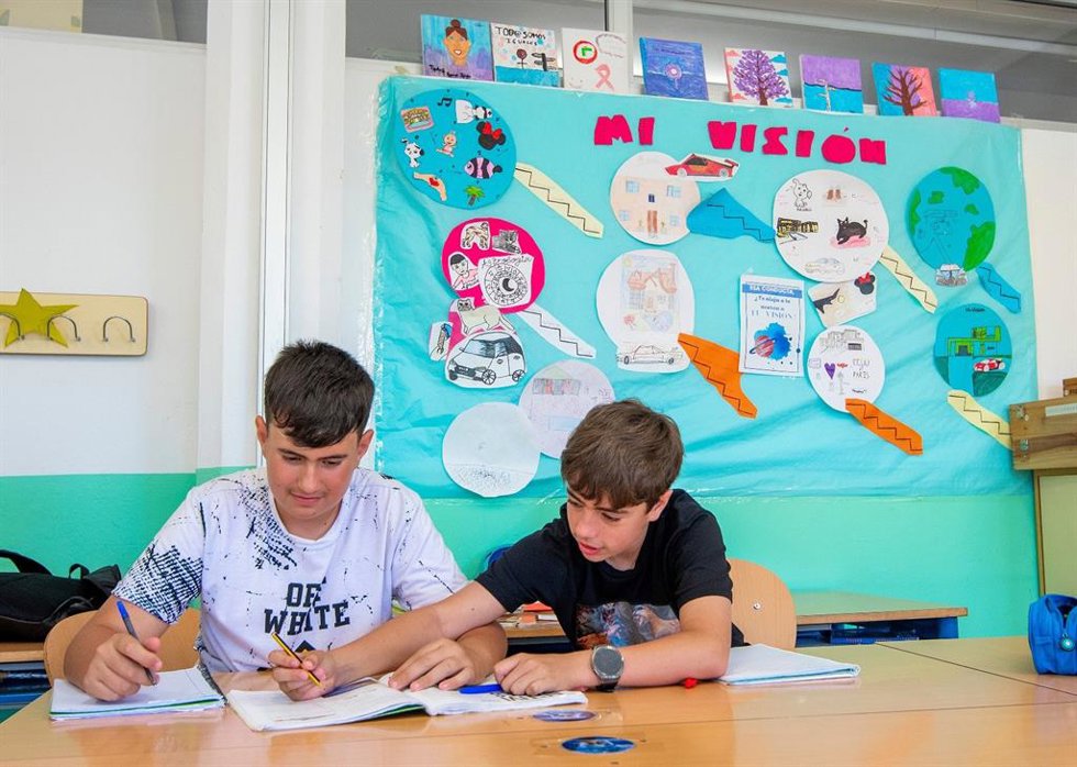 Dos escolares realizando actividades de educación ambiental.