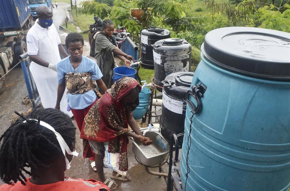 MPONDWE, May 24, 2026  -- A health officer (L, in white) directs inbound passengers to wash their hands at Mpondwe border point, western Uganda, May 23, 2026.   