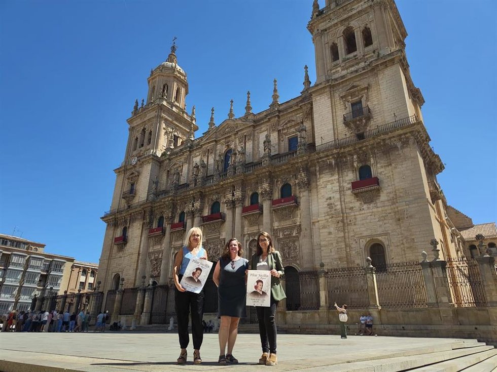 María Espejo, Desirée Amaro y África Colomo muestran carteles del homenaje a Pilar Sicilia de Miguel.