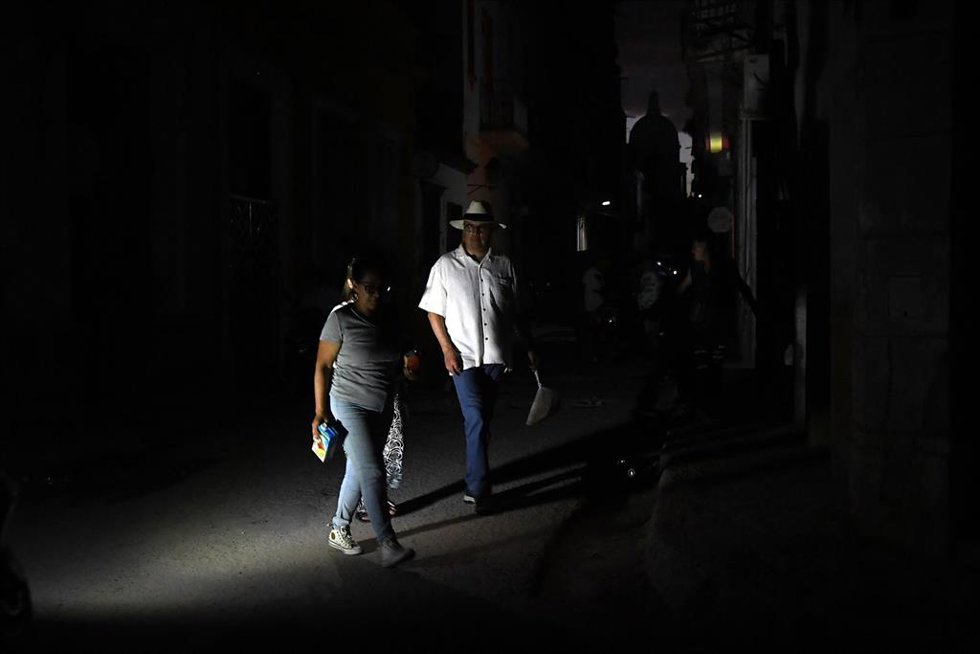 Archivo - Varias personas caminan por una calle de la capital de Cuba, La Habana, durante un apagón a causa de la crisis energética por el refuerzo del bloqueo de Estados Unidos (archivo)