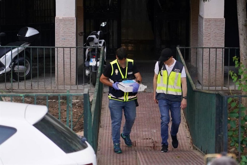 Dos investigadores de la Policía Nacional en el lugar donde se ha producido el asesinato de una mujer en Málaga.