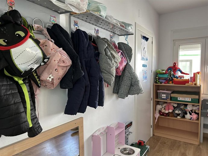 Archivo - Abrigos y mochilas colgados en la percha de un aula.