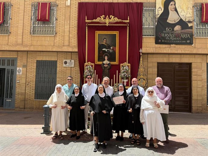 El concejal de Cultura del Ayuntamiento de Almería, Diego Cruz, entre el primer premio del X Concurso Exorno de Altares del Corpus Christi a la hermandad de la Macarena