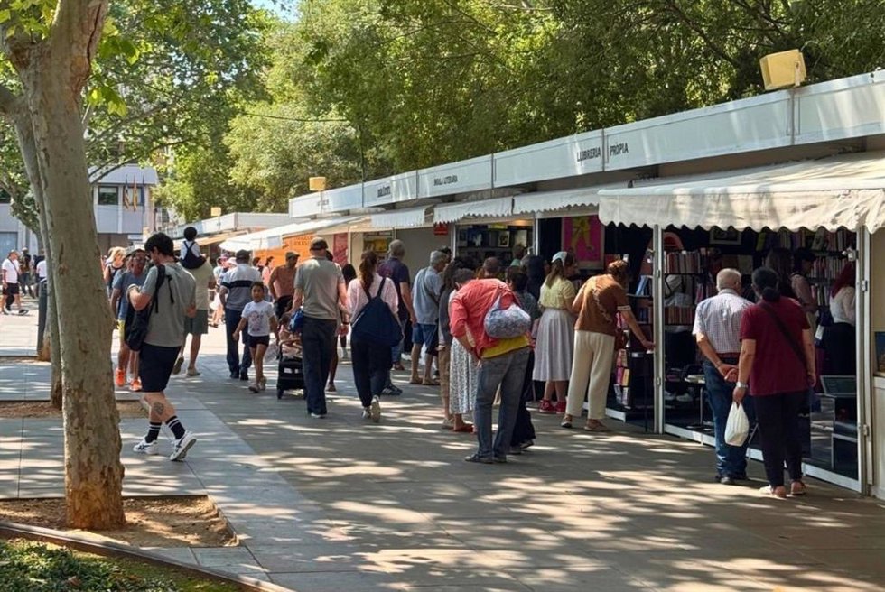 Personas pasean por las casetas de la Feria del Libro de Palma en la plaza de España.