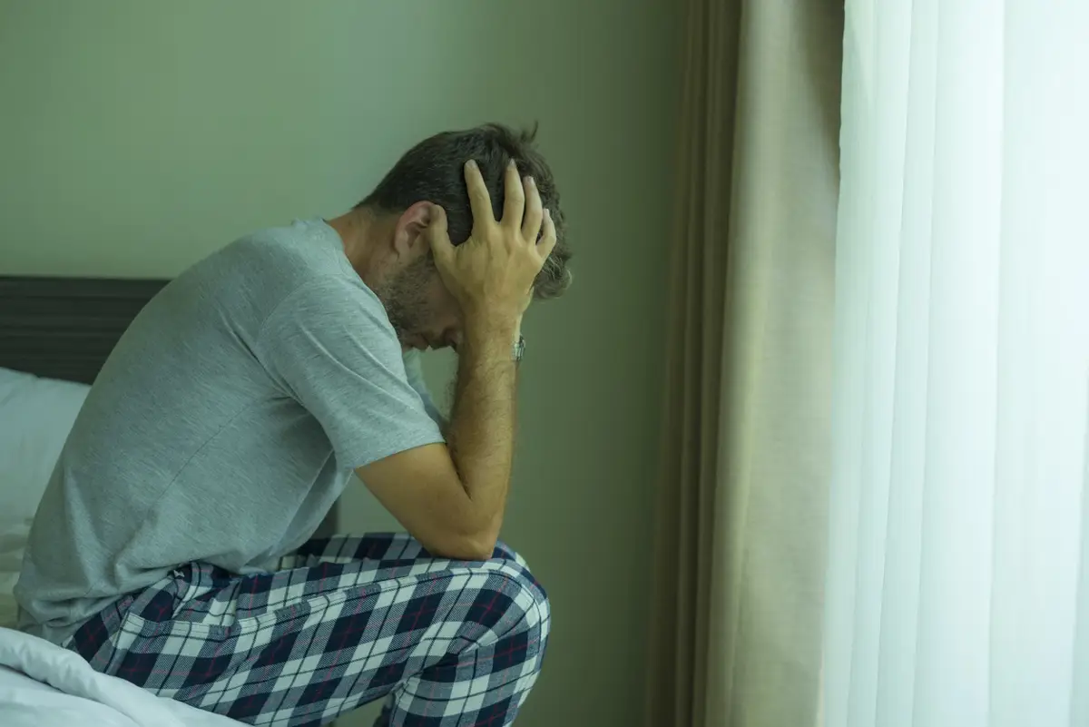 Hombre triste sentado en la cama. - ISTOCK - Archivo