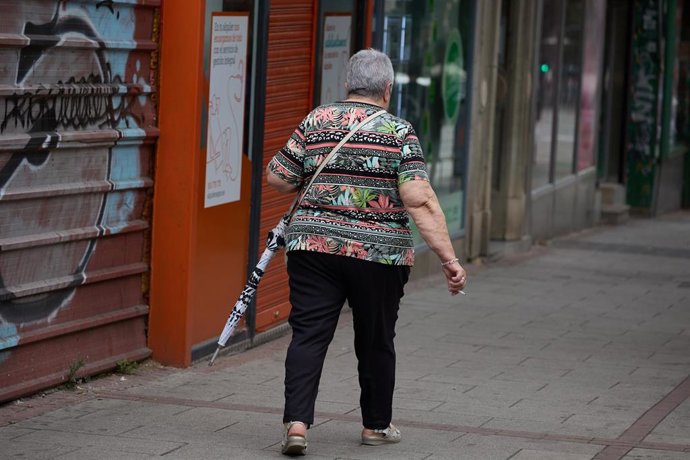 Archivo - Una mujer camina con un paraguas en la mano. Imagen de archivo