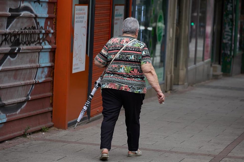 Archivo - Una mujer camina con un paraguas en la mano. Imagen de archivo
