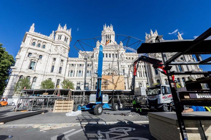 Varias personas trabajan en el montaje de escenarios para la Santa Misa del Papa León XIV en Cibeles