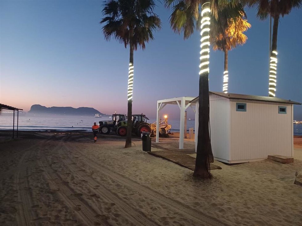 Operarios trabajando en el arenal de la playa del Rinconcillo en Algeciras (Cádiz)