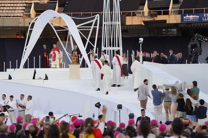 Varias personas transportan una cruz durante la vigilia de oración, en el Estadio Olímpico Lluís Companys.