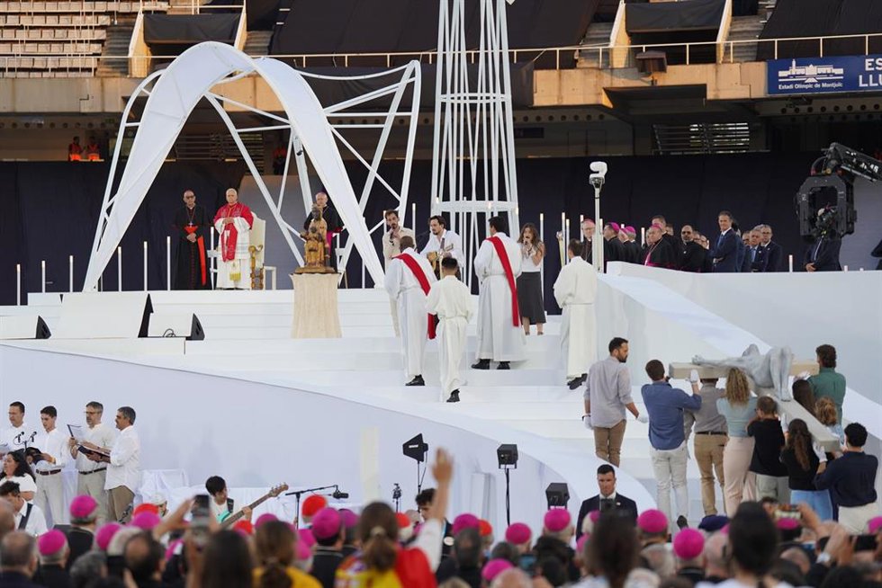 Varias personas transportan una cruz durante la vigilia de oración, en el Estadio Olímpico Lluís Companys.