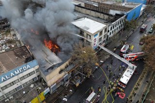 Santiago, 9 de junio de 2026.  Incendio afecta a locales comerciales ubicados en Alameda entre Chacabuco y Maipu en la comuna de Santiago, bomberos trabaja en el lugar  Diego Martin/Aton Chile