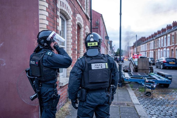9 de junho de 2026, Belfast, Antrim, Reino Unido: A polícia de choque chega ao local de um incêndio provocado por manifestantes em Belfast. A cidade ficou em chamas quando os moradores saíram às ruas para protestar contra o esfaqueamento de um homem do no