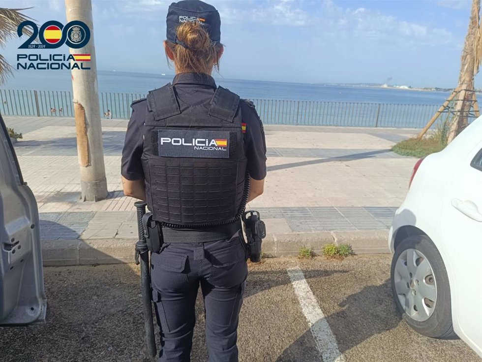 Una agente de la Policía Nacional, de espaldas.