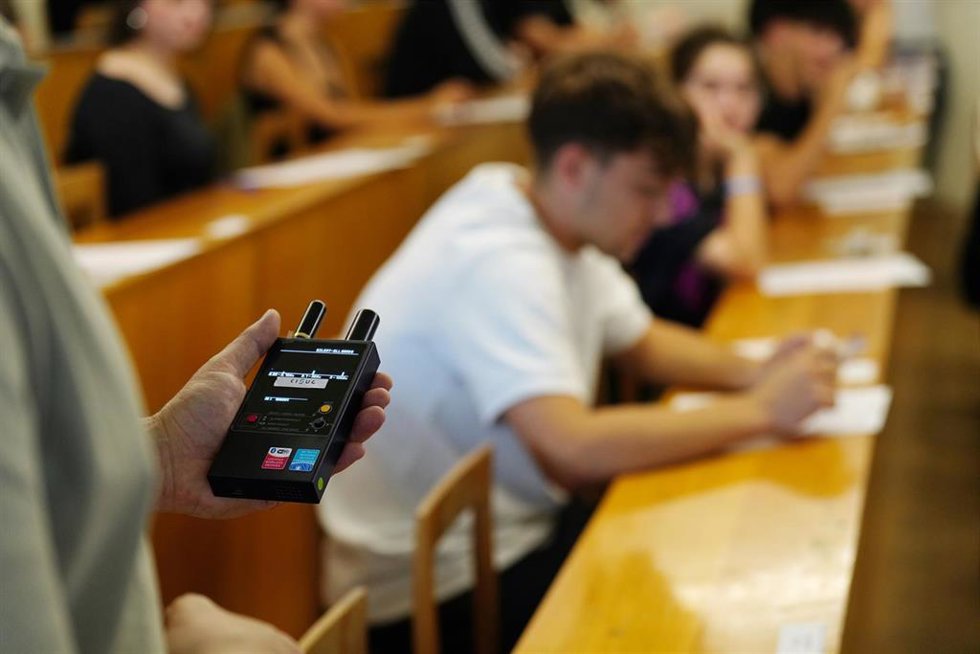 Una profesora revisa que no haya dispositivos electrónicos escondidos durante la PAU 2026 en una facultad.