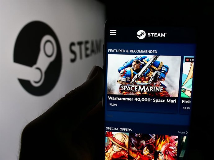 Archivo - August 8, 2024, Germany: In this photo illustration, a person is holding a smartphone with the webpage of US video game distribution company Steam (Valve) in front of logo.
