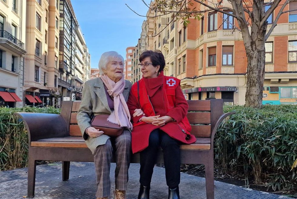 Archivo - Una voluntaria de la Cruz Roja con una persona mayor.