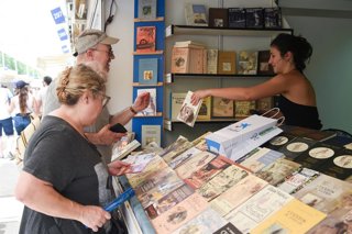 Archivo - Dos persona observan un libro durante la 84ª Feria del Libro de Madrid, en el parque del Retiro, a 31 de mayo de 2025, en Madrid (España). Esta edición de la Feria del Libro está dedicada a la ciudad de Nueva York y se prolongará hasta el 15 de 