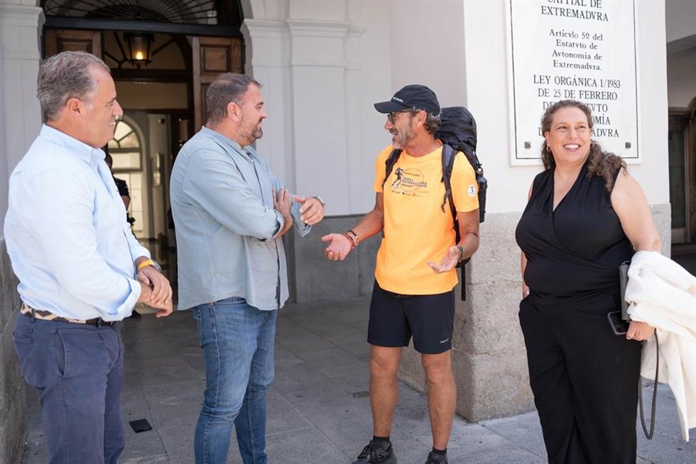 El alcalde de Mérida, Antonio Rodríguez Osuna, recibe al senderista Manuel Calderón en la puerta del ayuntamiento tras completar la vuelta a Extremadura caminando.