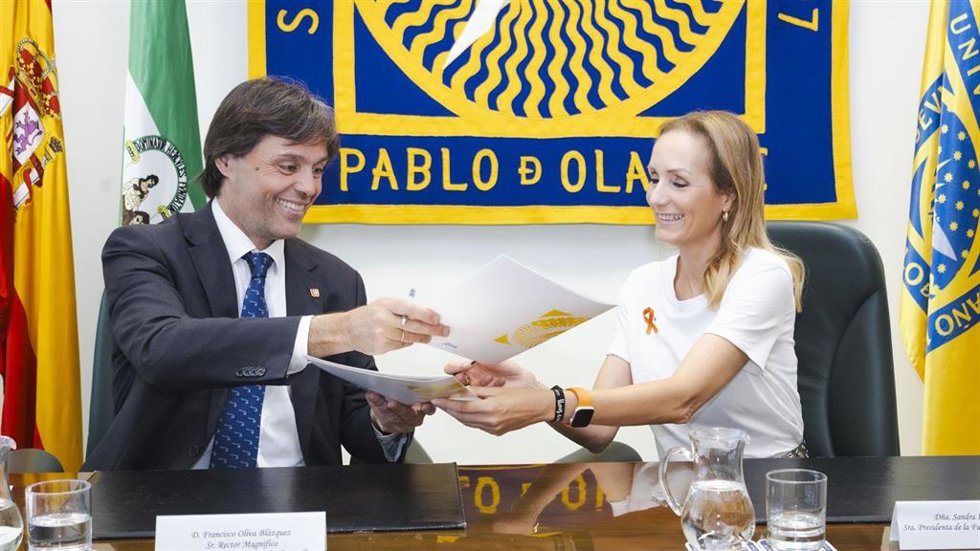 El rector de la Universidad Pablo de Olavide, Francisco Oliva, y la presidenta y fundadora de la Fundación Sandra Ibarra, Sandra Ibarra, firman un acuerdo de colaboración