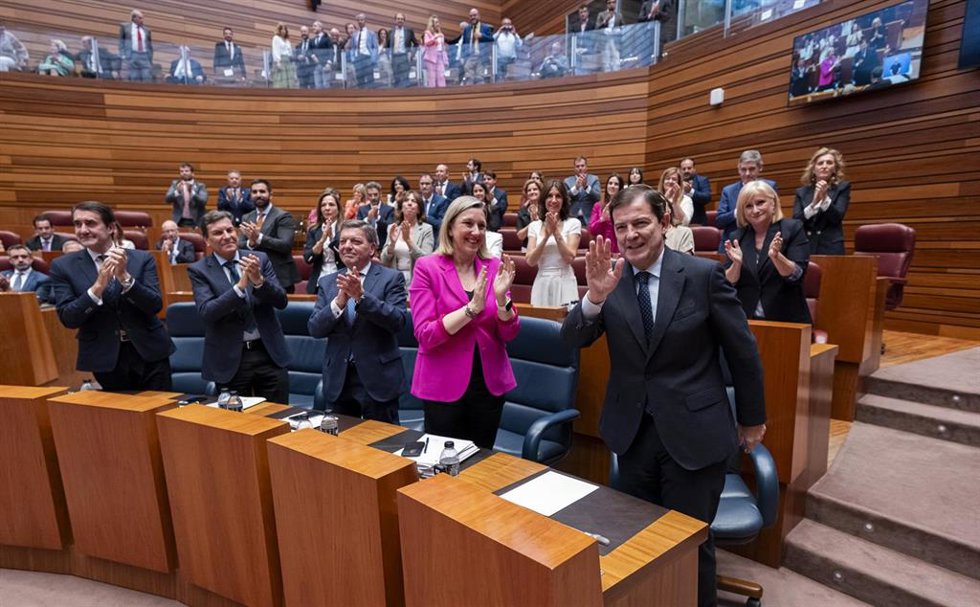 El presidente de la Junta de Castilla y León, Alfonso Fernández Mañueco (d), es felicitado tras ser investido para un tercer mandato, en las Cortes 