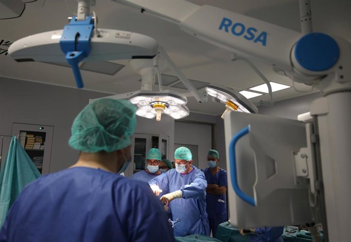 Pablo Navarro (en el centro) y  Fernando Mozo durante una intervención realizada con el robot 'ROSA'.