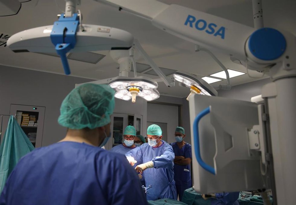 Pablo Navarro (en el centro) y  Fernando Mozo durante una intervención realizada con el robot 'ROSA'.