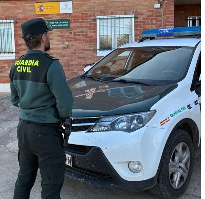 Archivo - Un agente de la Guardia Civil frente a su vehículo. Foto de archivo.