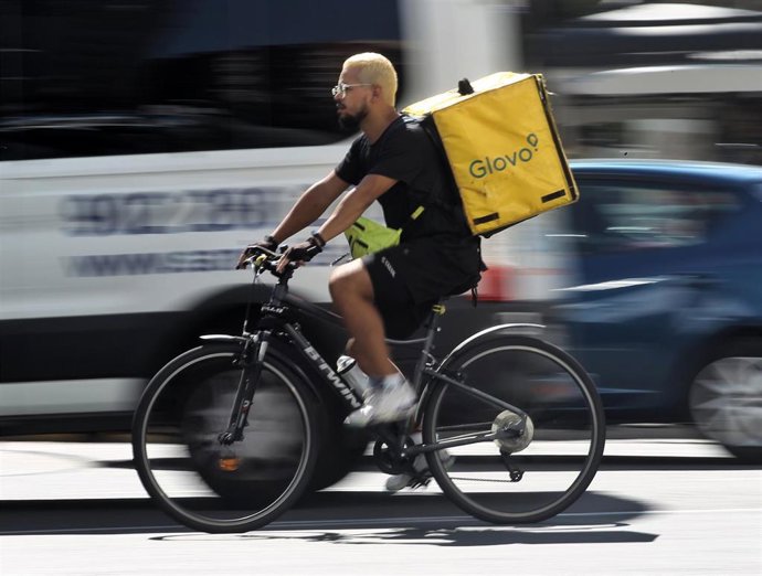 Archivo - Un rider de la empresa de reparto de comida a domicilio Glovo, pasea por una calle de Madrid con su bicicleta.