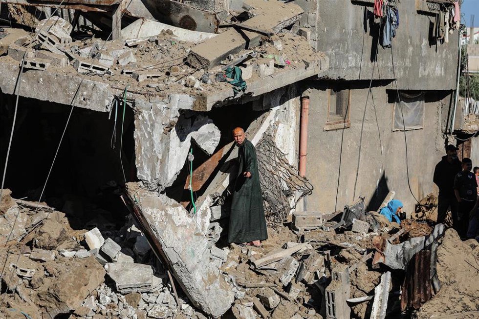 Un hombre sobre los escombros de un local bombardeado por Israel en Deir al Balá, en la Franja de Gaza