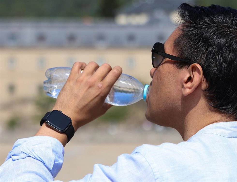 Archivo - Un hombre bebe agua de una botella de plástico.