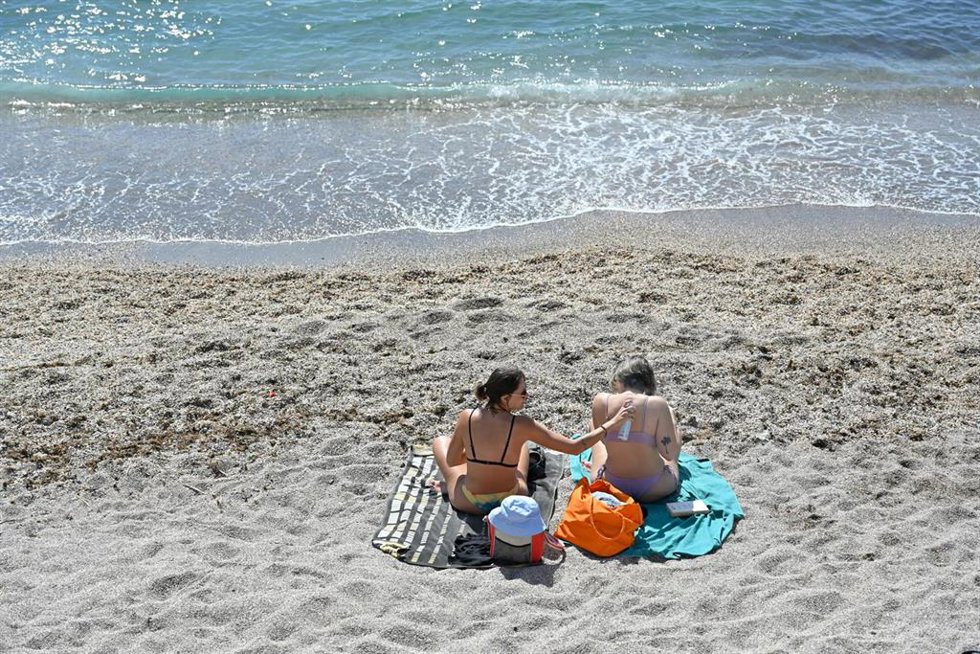 Archivo - Unas chicas toman el sol en bañador junto al mar aprovechando las altas temperaturas, a 11 de marzo de 2023, en Murcia, Región de Murcia (España).