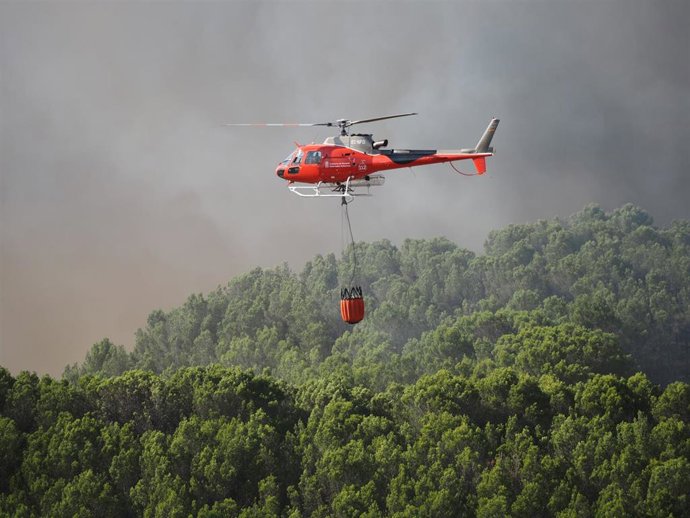 Archivo - Un helicóptero trabaja en la extinción de un incendio.
