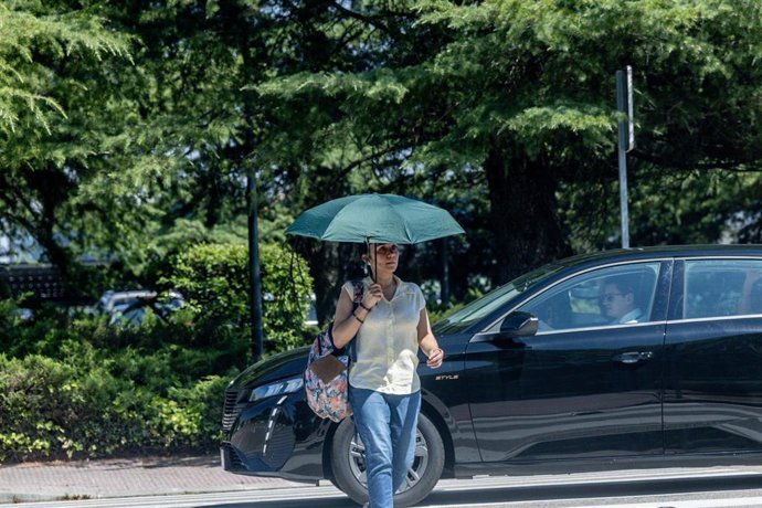 Archivo - Una persona con paraguas, a 27 de junio de 2025, en Madrid (España). La AEMET ha emitido un aviso especial por ola de calor que se extenderá desde el sábado hasta al menos el martes, afectando a gran parte de España. Se esperan temperaturas supe