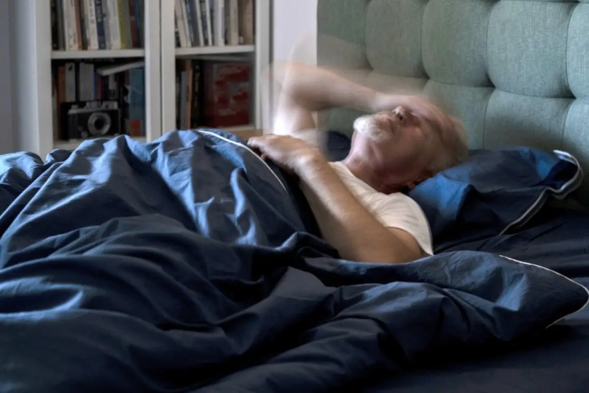Hombre con espasmos, dormir, insomnio