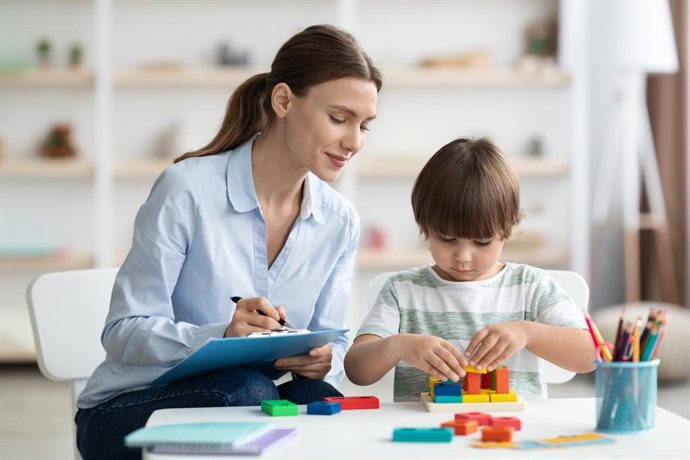Archivo - Terapeuta supervisa el trabajo de un niño.