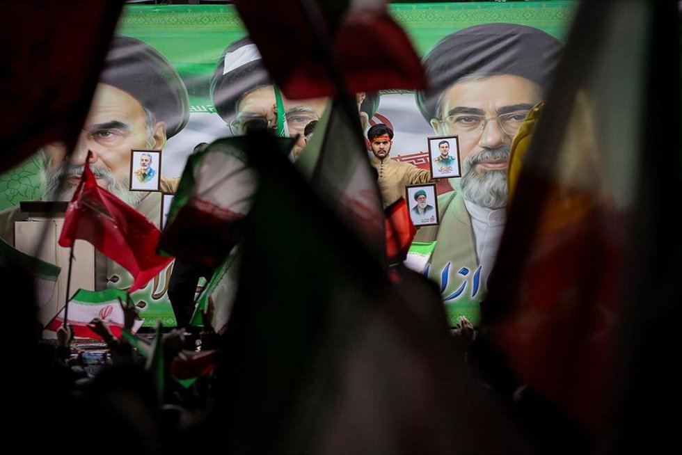 Manifestantes sostienen retratos y ondean banderas iraníes frente a grandes imágenes del recién nombrado líder supremo de Irán, el ayatolá Mojtaba Jamenei, durante una manifestación organizada por el Estado en Irán.