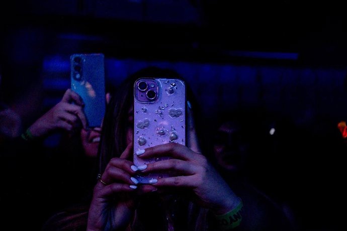 Archivo - Varias personas usan el móvil en un concierto, a 4 de febrero de 2026, en Madrid (España). El fundador de Telegram, Pavel Durov, ha instado a los españoles a mantenerse "vigilantes", exigir transparencia y luchar por sus derechos después de que 