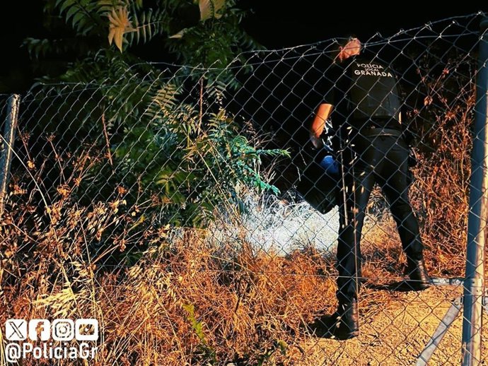 Un agente de la Policía Local de Granada interviene en la extinción de un conato de incendio en el Sacromonte.