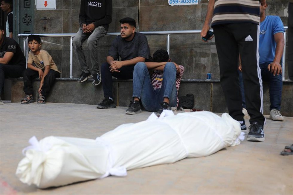 Palestinos junto a un muerto por un bombardeo de Israel en junio de 2026 contra la Franja de Gaza, a pesar del alto el fuego pactado en octubre de 2025 (archivo)