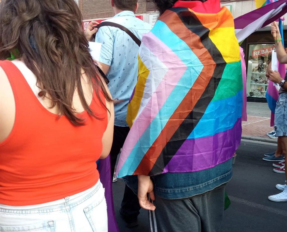 Archivo - Un joven se cubre con una bandera LGTBIQ+ durante una manifestación.