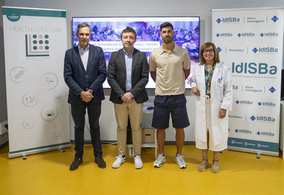 El futbolista Marco Asensio y la gerente de Son Espases, Cristina Granados, en la firma del acuerdo para poner en marcha el programa de atención a los pacientes oncológicos pediátricos.
