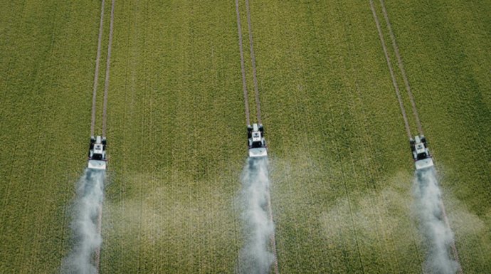 Archivo - Imagen de recurso de vehículos agrículos en pleno trabajo sobre un cultivo.