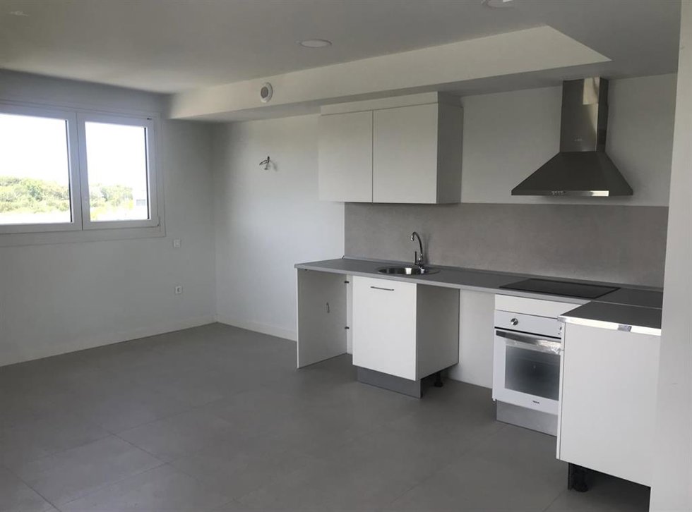 Cocina americana y ventana de un vivienda de alquiler asequible en Valdefierro