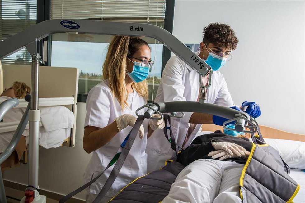 Dos estudiantes de una FP sanitaria hacen prácticas con un maniquí.