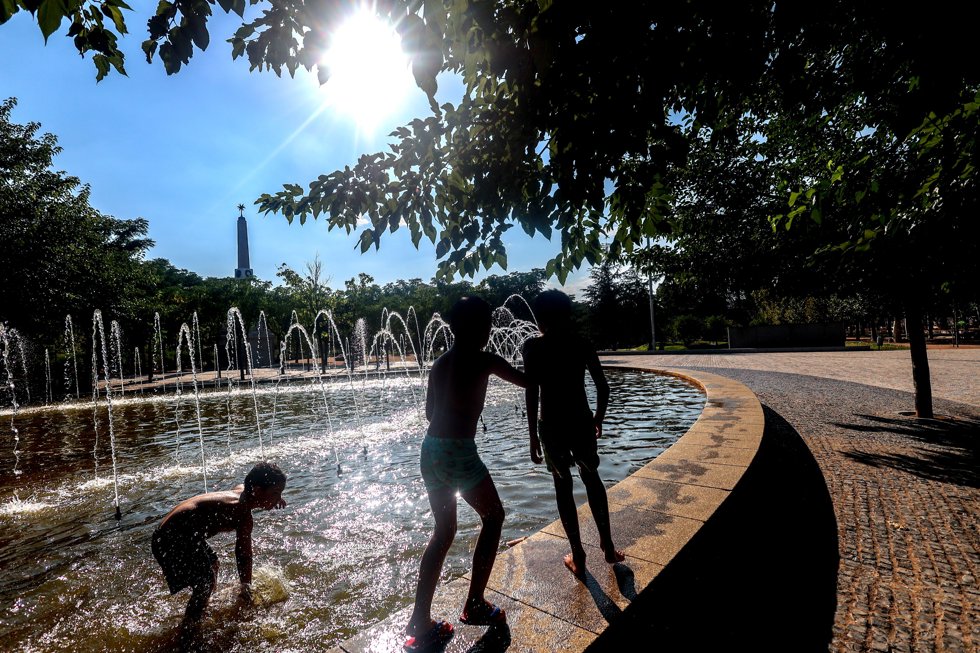 Tres niños se refrescan en una fuente durante la tercera ola de calor en Madrid, en el parque Madrid Río, a 3 de agosto de 2024, en Madrid (España).